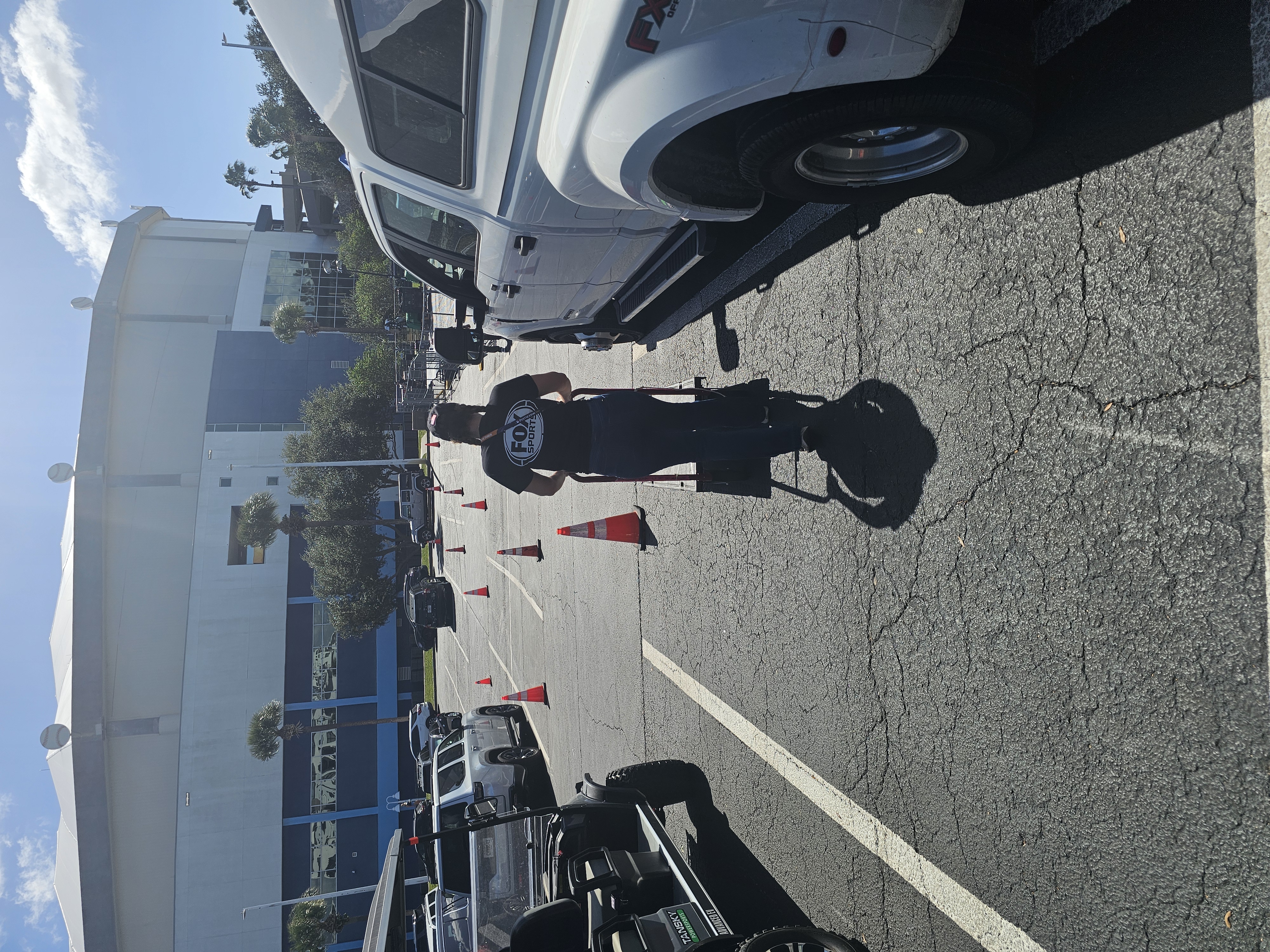 FOX Sports staff member moving a hand truck beside the delivery vehicle outside Tropicana Field